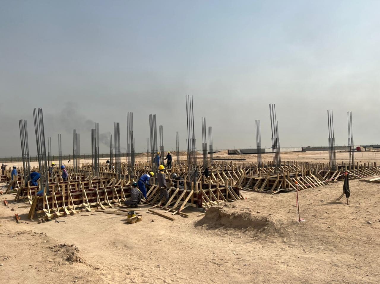 Mass foundation works — rebar and formwork crews on site
